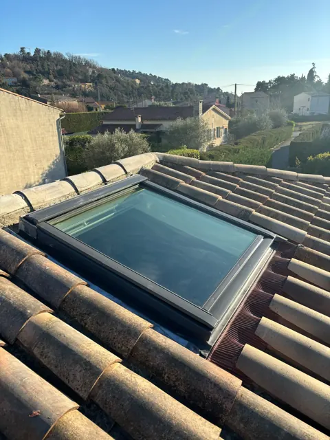 Fenêtre de toit posée dans une toiture en tuiles